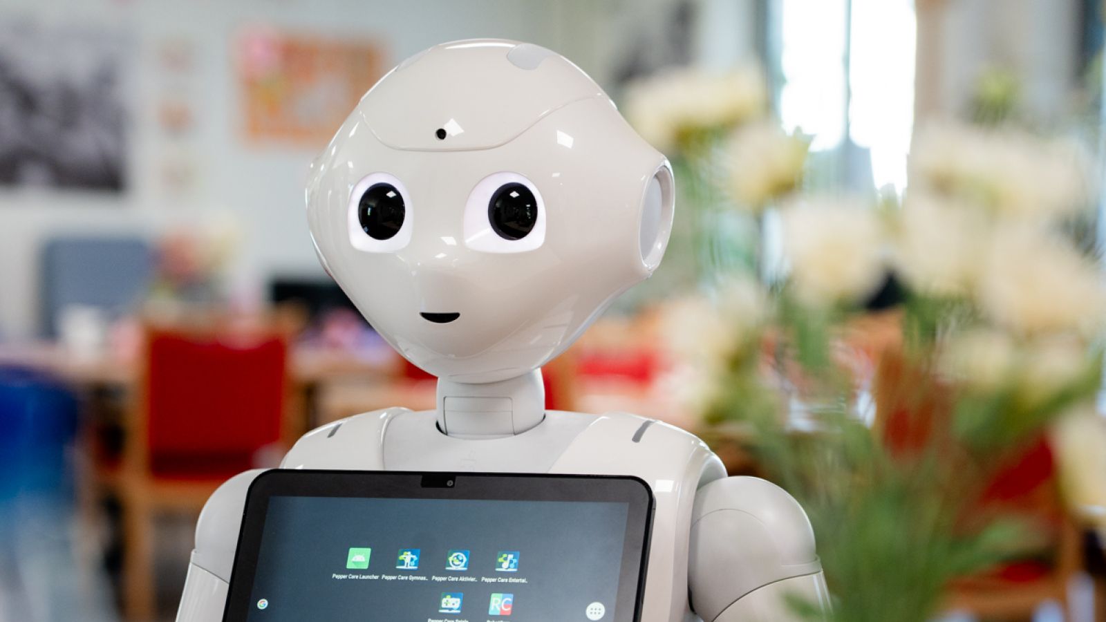 Humanoider weißer Roboter mit Touch-Tablet auf der Brust